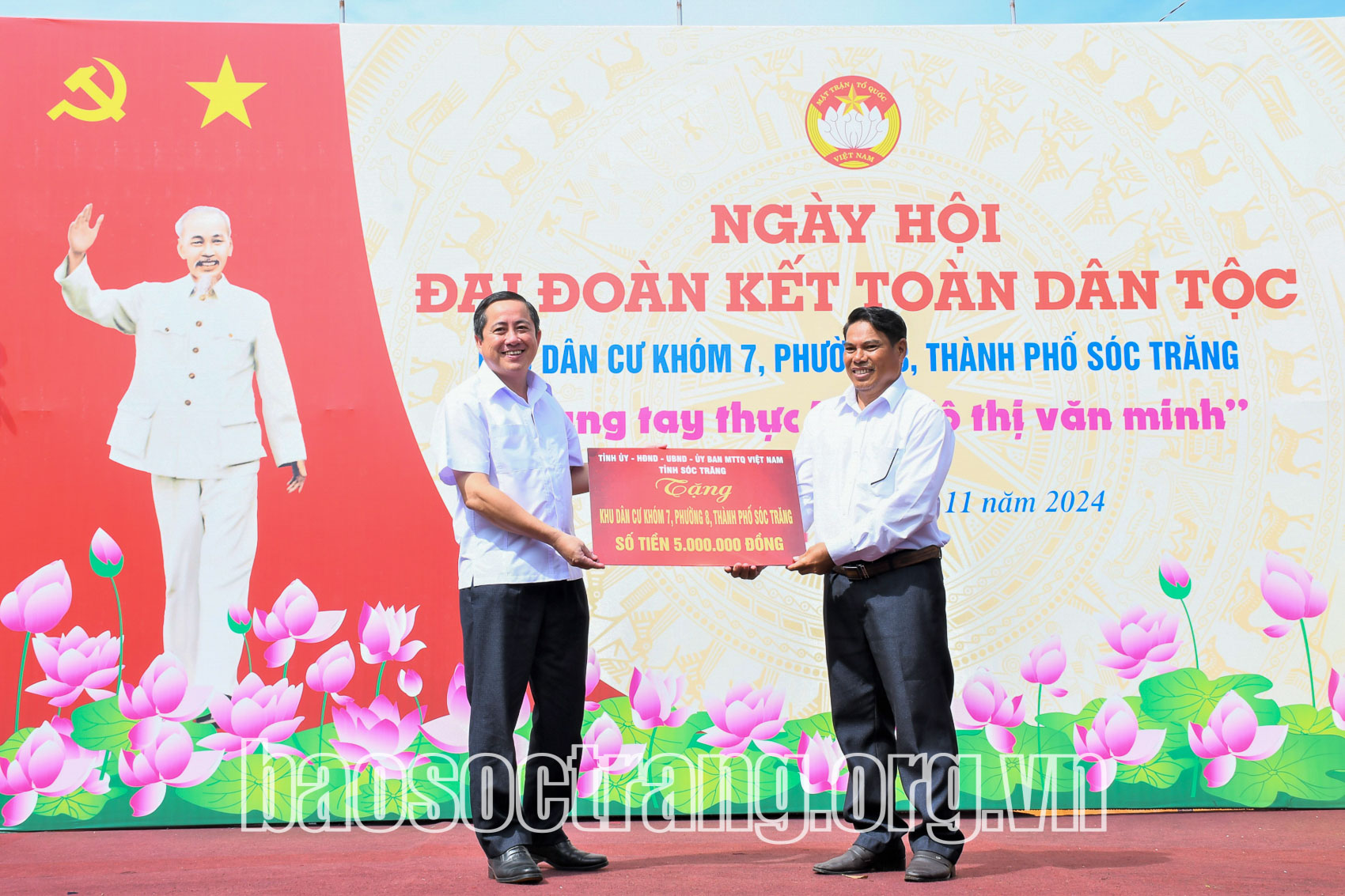 Đồng chí Ngô Hùng - Ủy viên Ban Thường vụ Tỉnh ủy, Chủ tịch Ủy ban MTTQ Việt Nam tỉnh Sóc Trăng (bìa trái) trao bảng tượng trưng tặng quà cho khu dân cư Khóm 7, Phường 8 (Ảnh: Hải Hà).